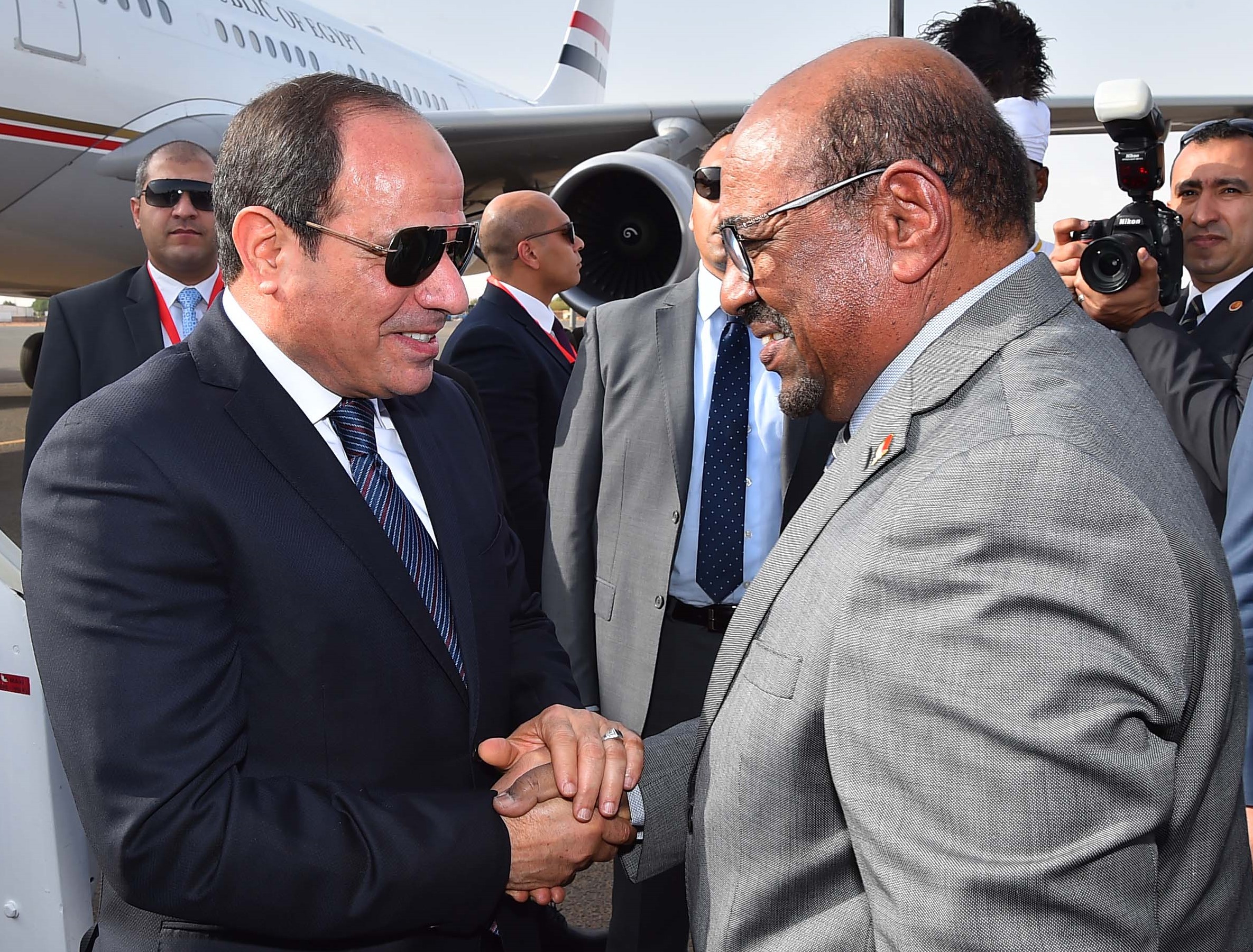 Sudanese President Omar al-Bashir (R) greeting his Egyptian counterpart Abdel Fattah al-Sisi upon his arrival at Khartoum International Airport in the Sudanese capital on 19 July 2018 (AFP)