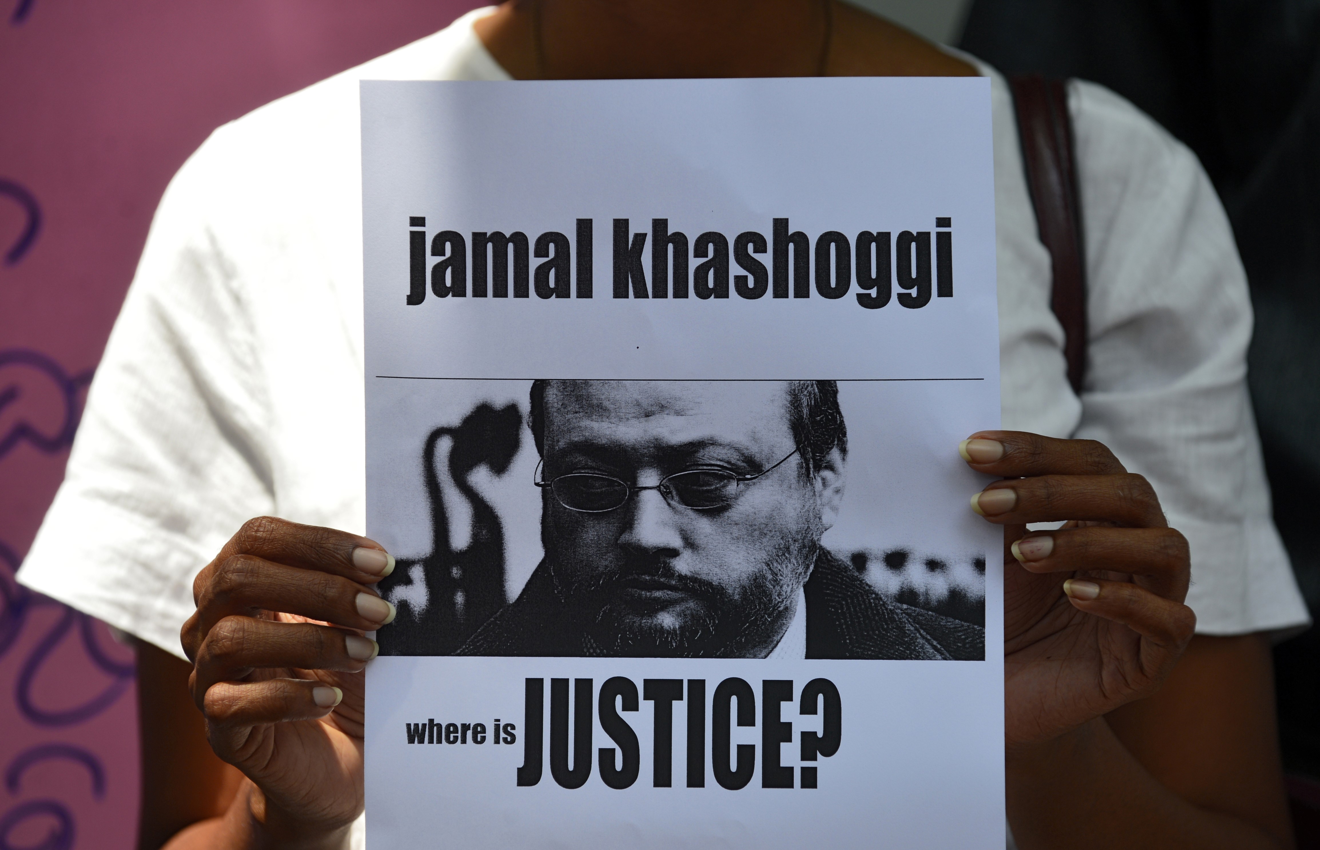 A Sri Lankan journalist holds a placard with the image of Saudi journalist Jamal Khashoggi during a demonstration outside the Saudi Embassy in Colombo on 25 October 2018 (AFP)