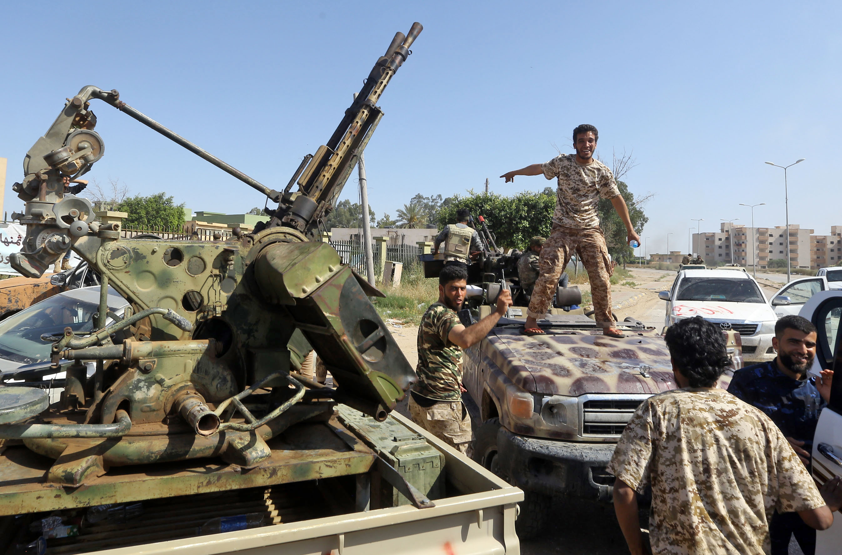 Forces loyal to Libya's Government of National Accord (GNA) gesture on 18 April, after taking control of the area of al-Aziziyah, located some 40 kilometres south of Tripoli (AFP)