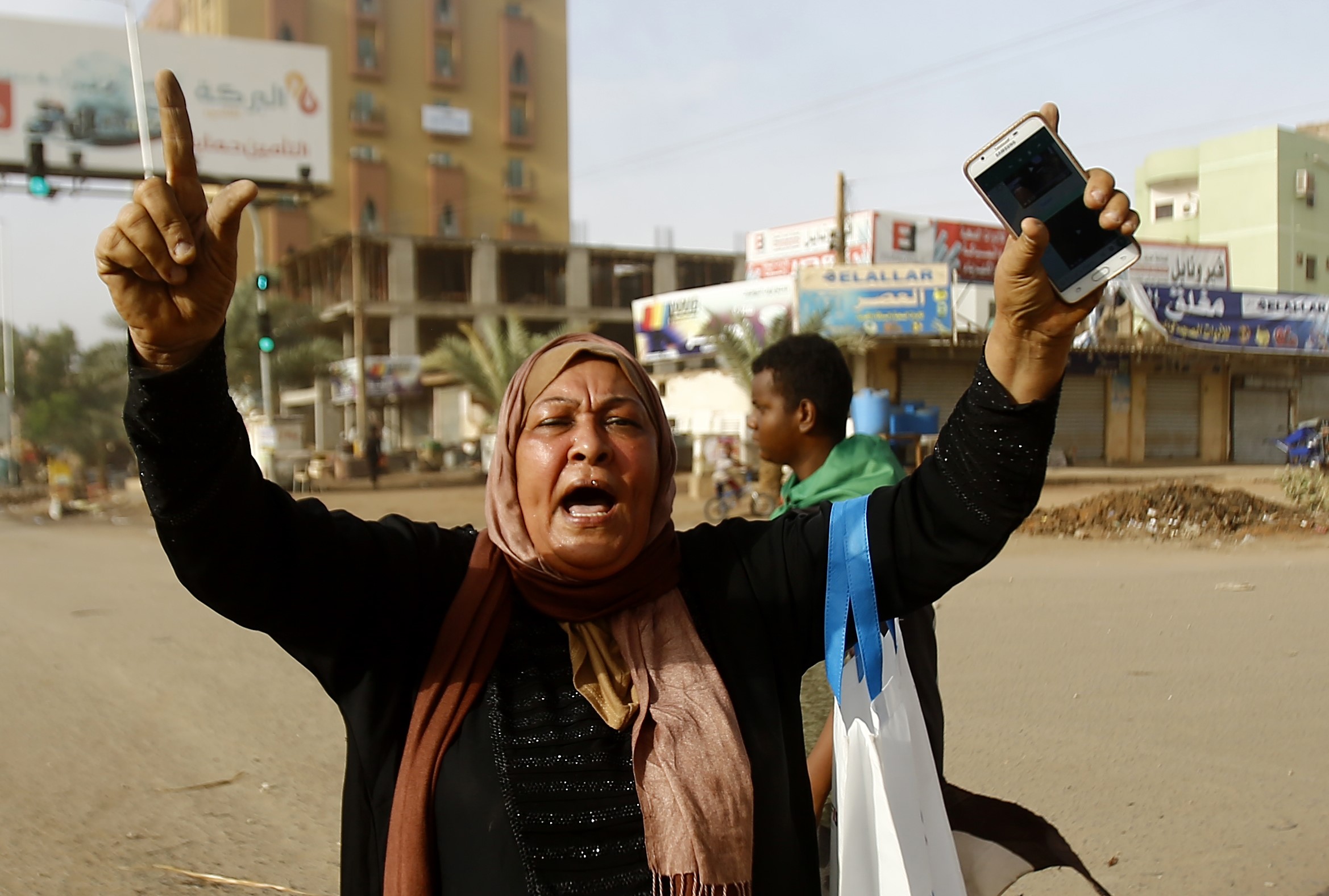 A Sudanese protester reacts as military forces tried to disperse a sit-in outside Khartoum's army headquarters on 3 June (AFP)