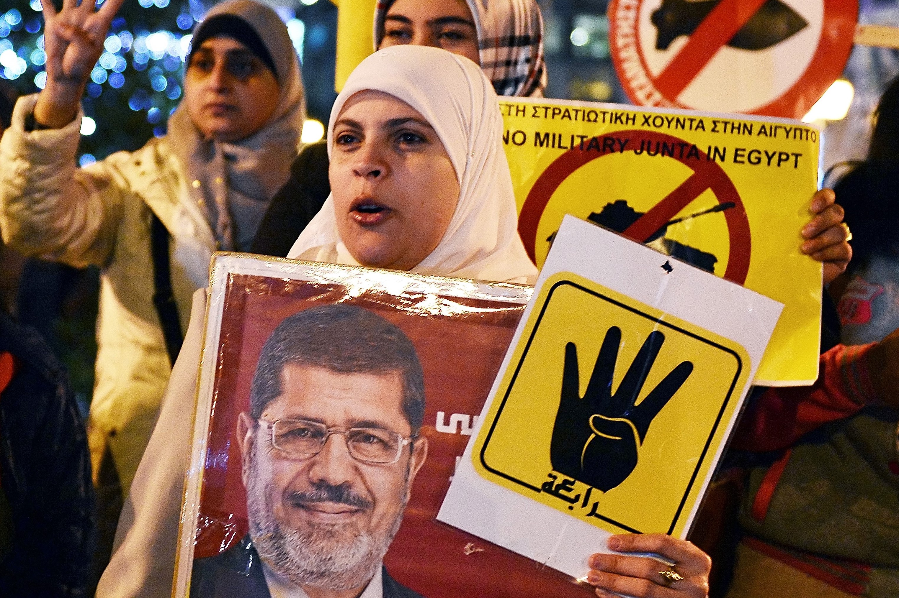   A woman holds up a banner of former Egyptian President Mohamed Morsi in anti-Sisi protest in Athenes in December 2015 (AFP)