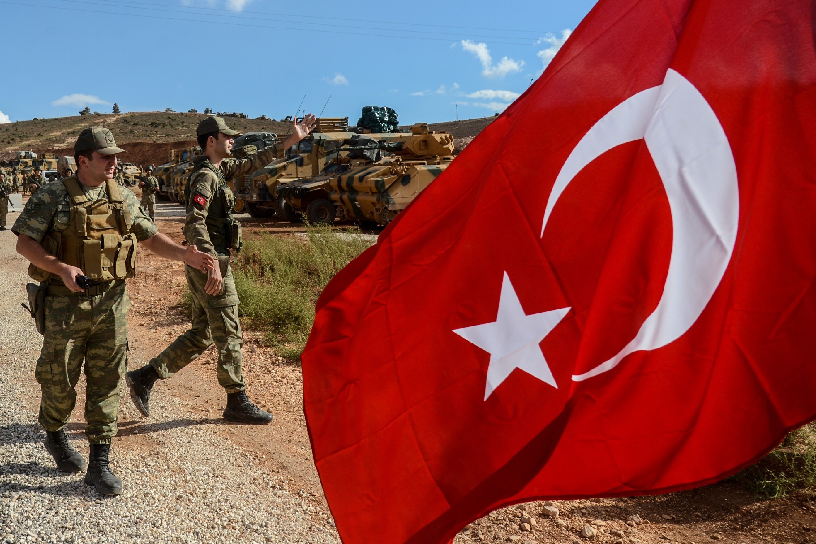  Turkish soldiers stand near armoured vehicles near the Turkey-Syria border near Reyhanli, Hatay, on 10 October, 2017 (AFP)
