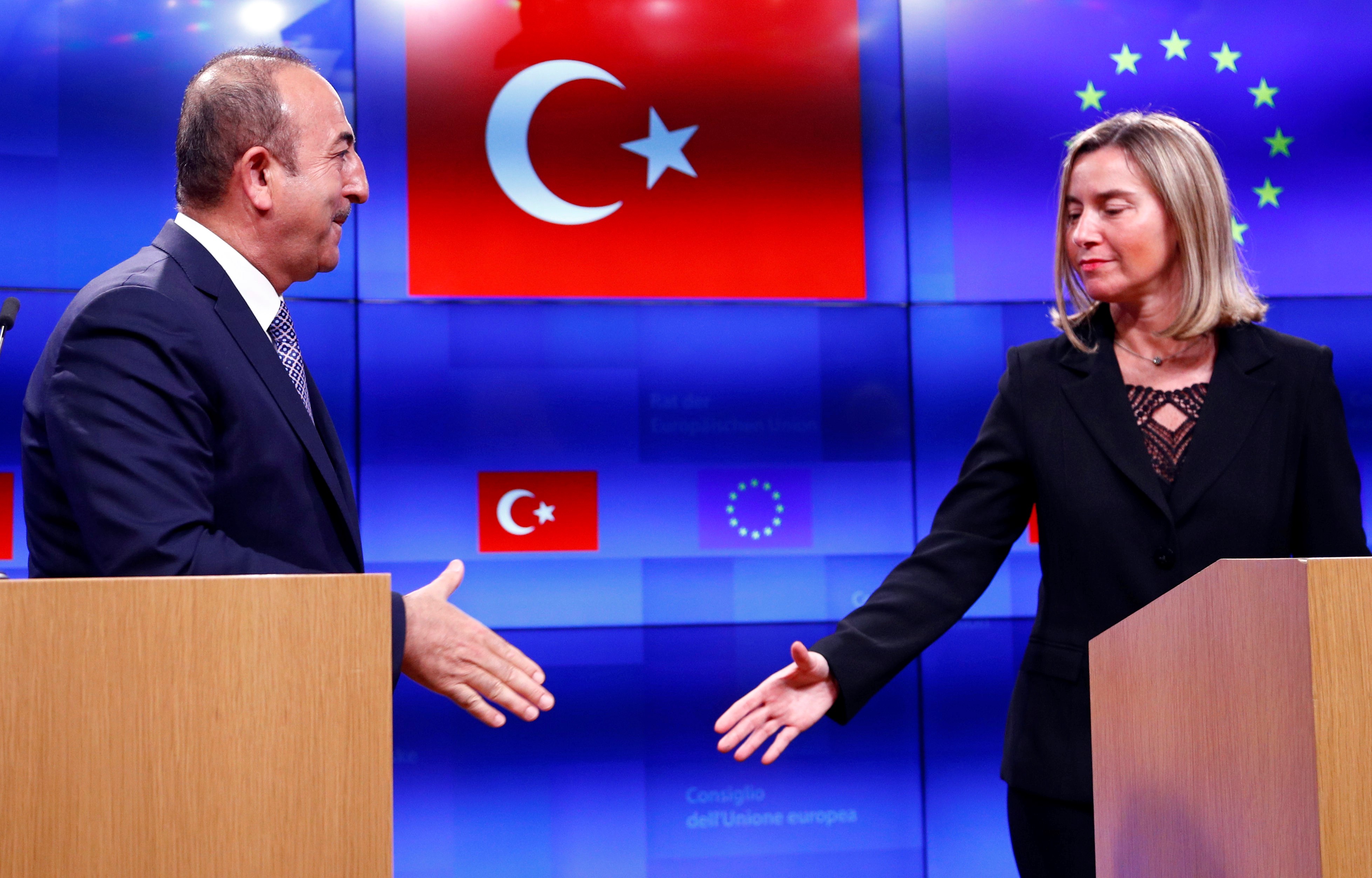  Turkish Foreign Minister Mevlut Cavusoglu shakes hands with European Union foreign policy chief Federica Mogherini  Belgium on 15 March (Reuters)
