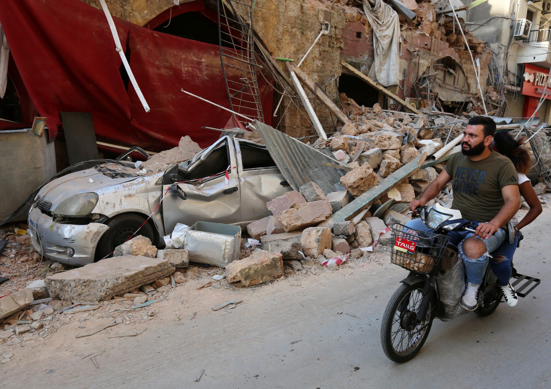 A man rides on a motorbike near rubble from damaged buildings in Gemmayzeh (Reuters)