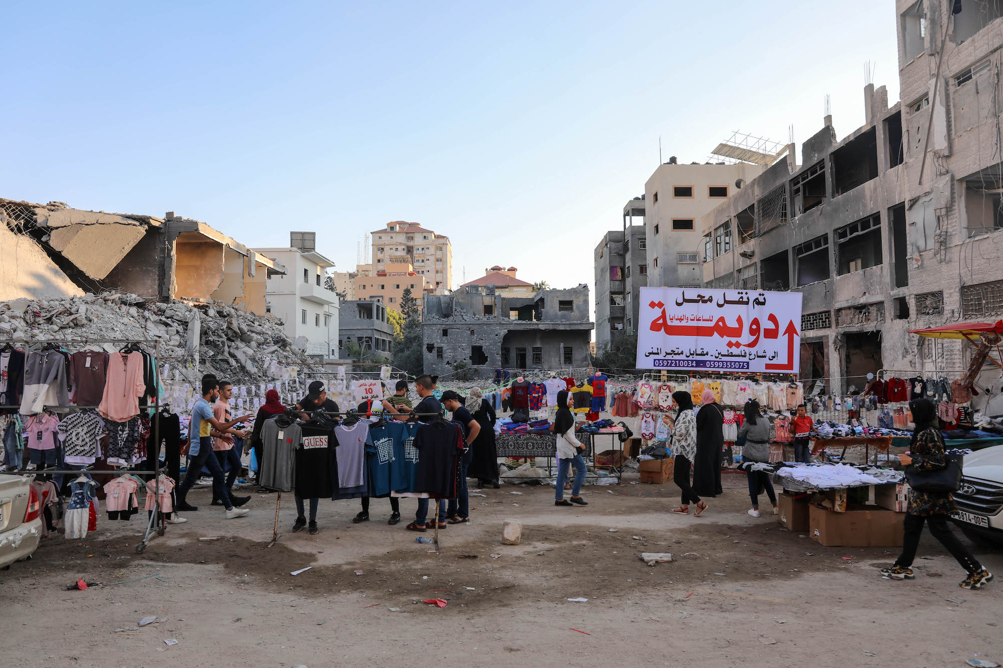 People gather outside destroyed Al-Shorouk shops
