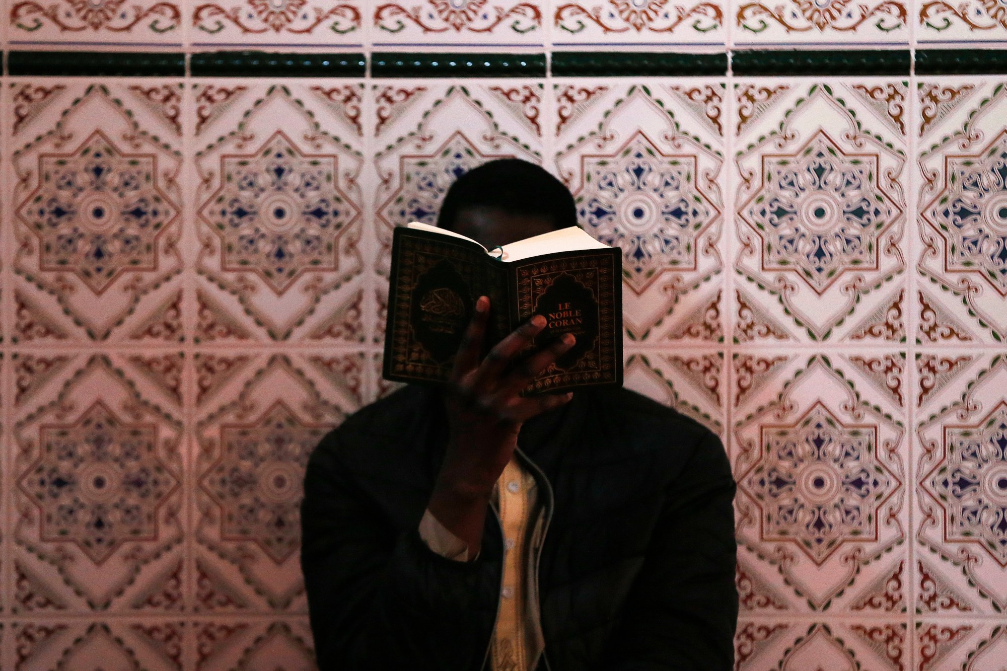 A Muslim man reads the Quran at the Ennour Mosque in the northwestern French city of Le Havre on 18 May 2018 during the Muslim holy month of Ramadan (AFP)