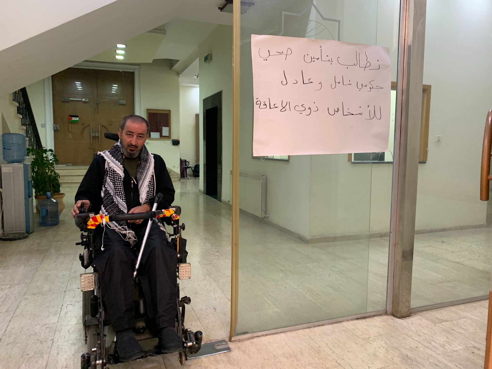 Activists have displayed signs reading "We demand government health care that is full and fair for people with disabilities" (MEE/Shatha Hammad)
