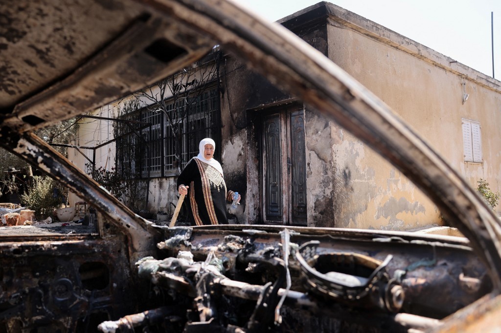 Une Palestinienne devant sa maison, incendiée la veille par des colons israéliens, à Turmus Ayya, près de la ville de Ramallah, en Cisjordanie occupée, le 22 juin 2023 (Ahmad Gharabi/AFP)