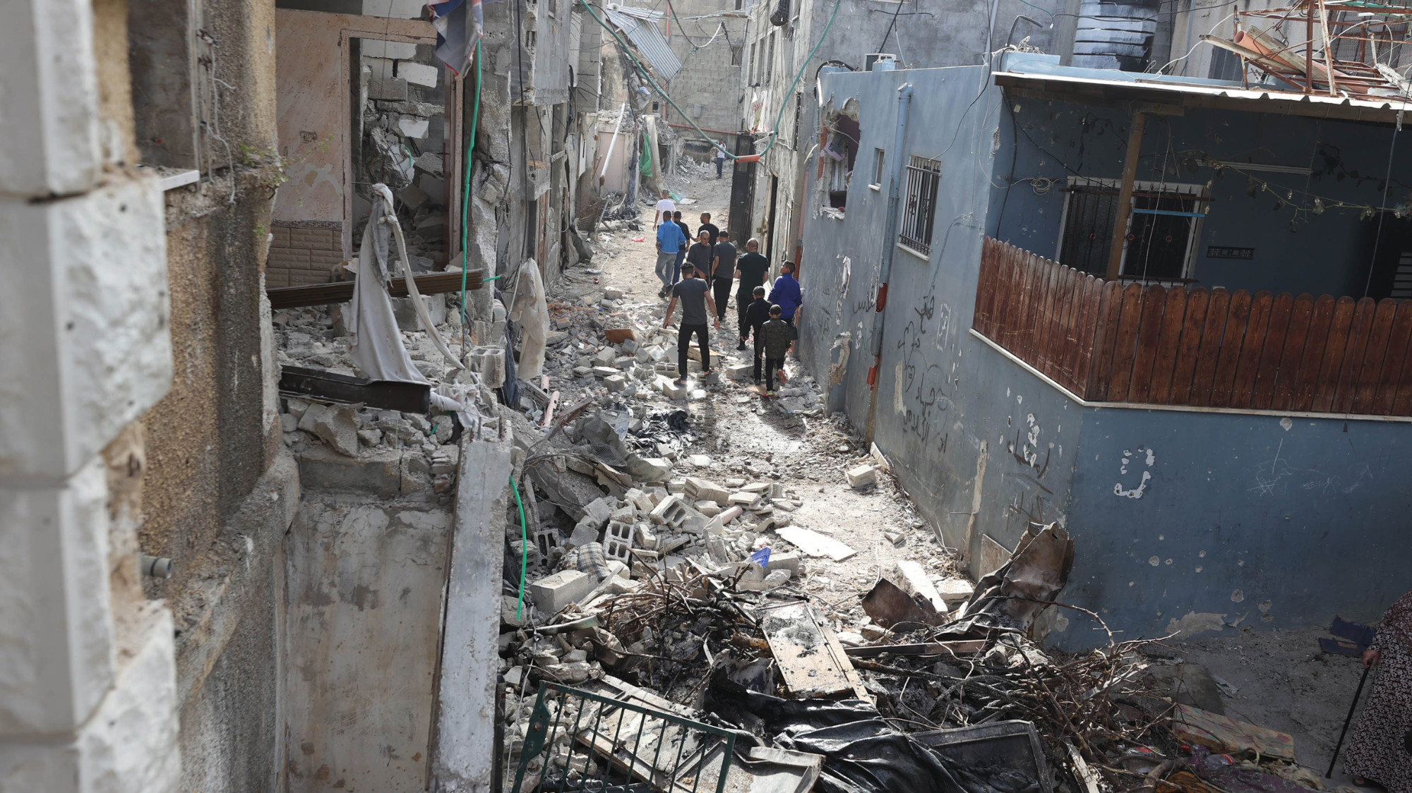 Palestinians walks amid the rubble of homes destroyed by Israeli forces in Tulkarm in the occupied West Bank, 21 April 2024 (MEE/Muhammad Ateeq)