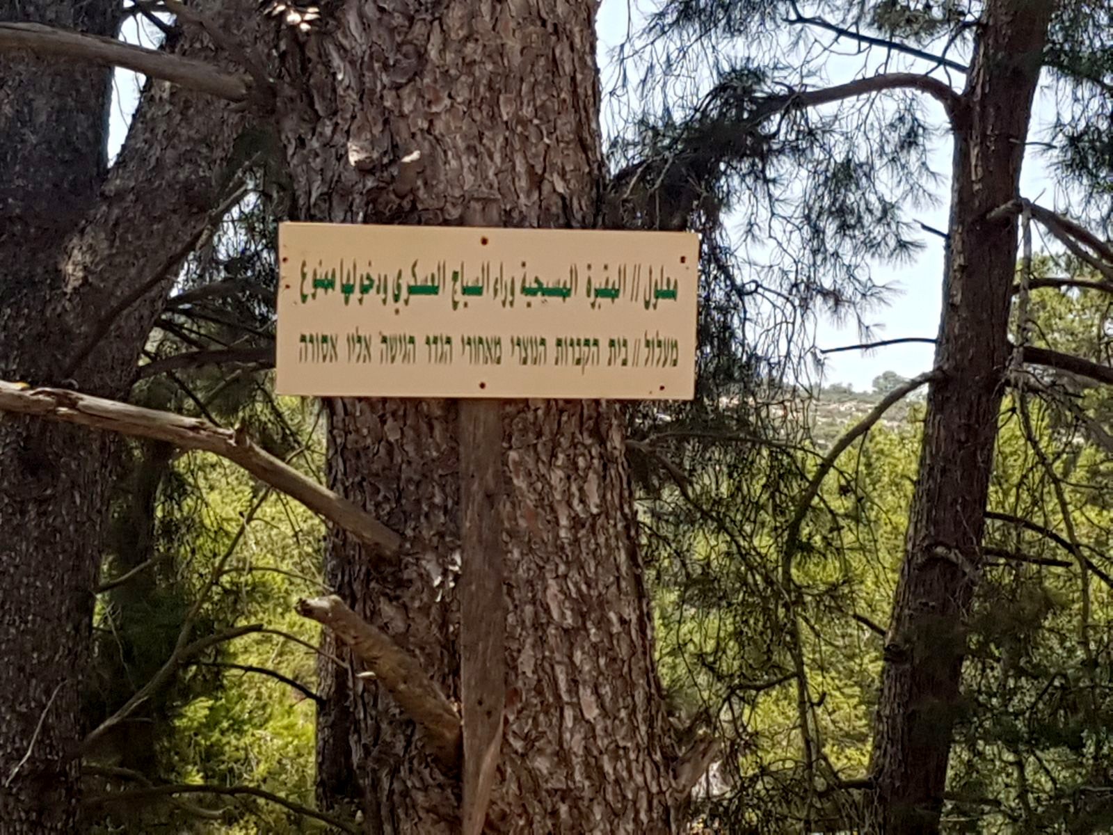 A Hebrew and Arabic sign in Ma'alul on the edge of the Israeli military base thst reads: Maalul | Christian cemetery behind the fence. Entry is forbidden