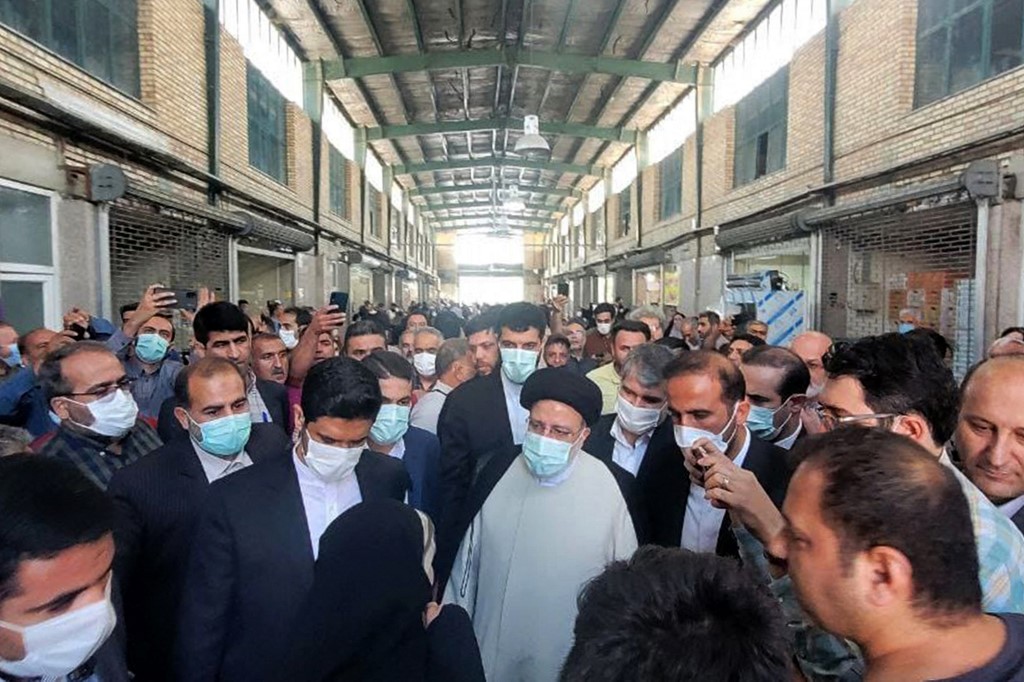 Iran's President Ebrahim Raisi (C) visiting a market in the capital, Tehran, on 13 May 2022 (AFP)