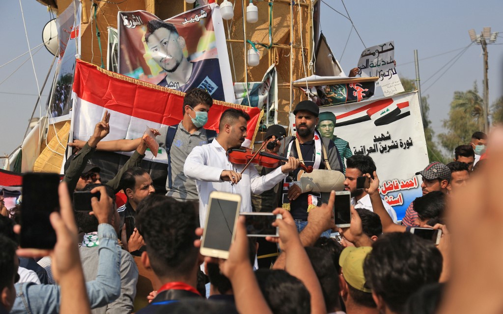 Iraqis take part in anti-government demonstrations in Karbala on 12 November (AFP)