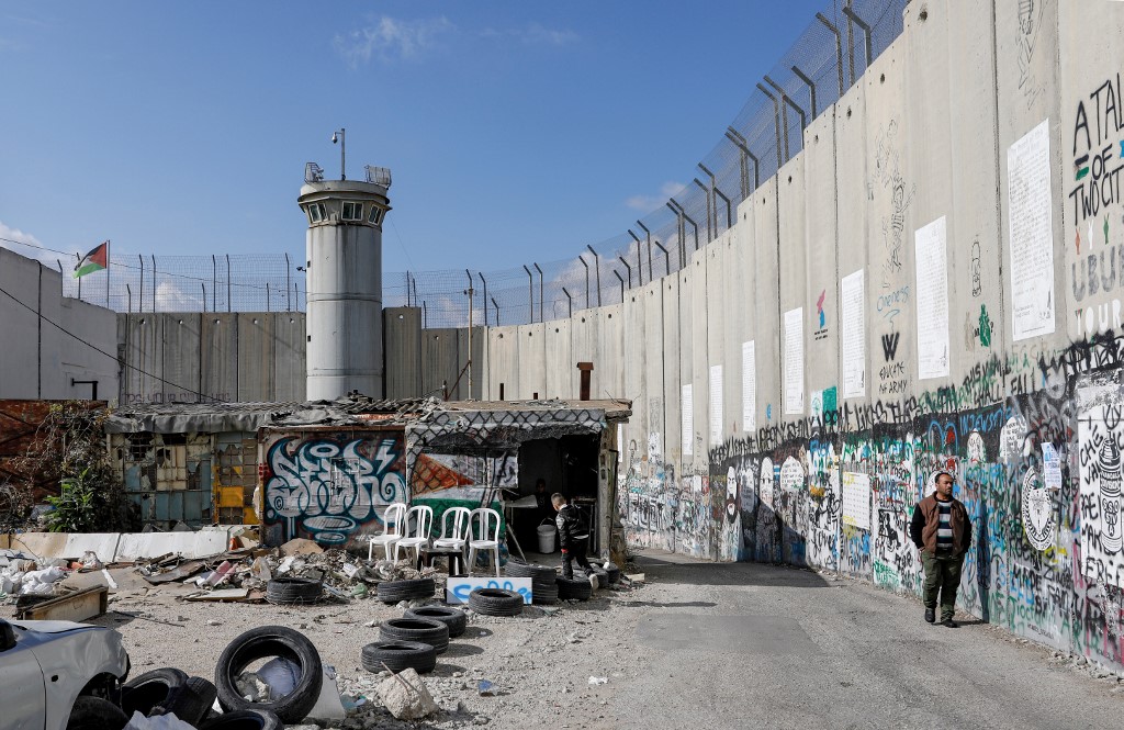 A man walks along Israel’s separation wall in Bethlehem on 7 December (AFP)
