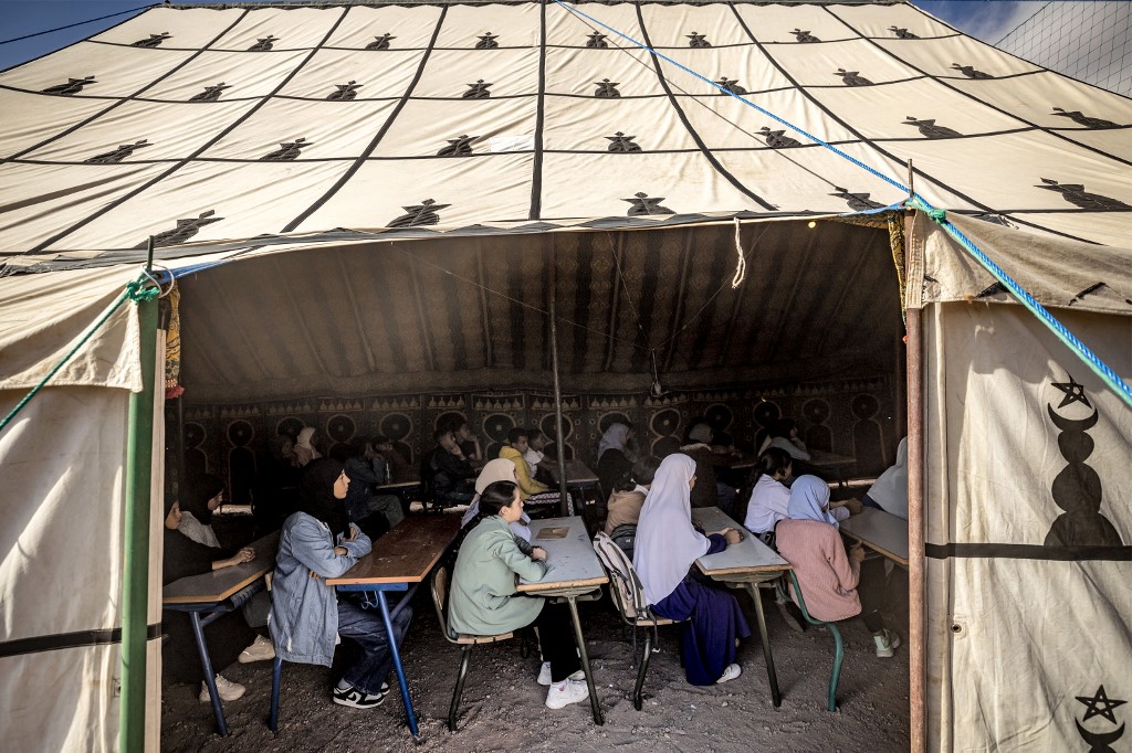 Students attend class in a tent at a make-shift school in the earthquake-hit village of Asni in al-Haouz province in the High Atlas mountains of central Morocco on September 18, 2023