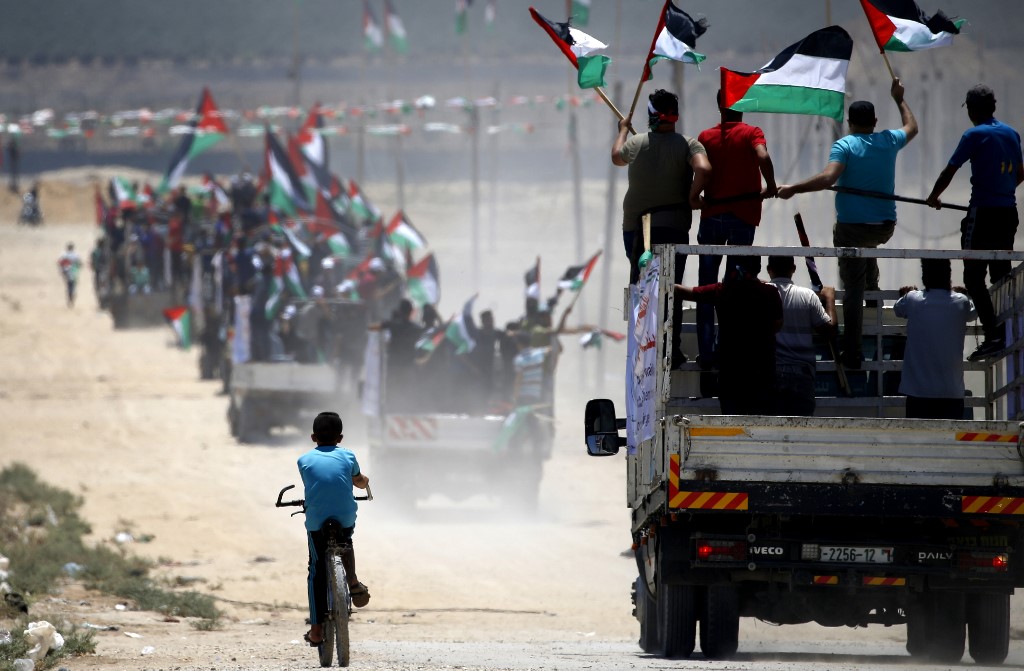 Palestinian demonstrators drive towards the Israel-Gaza fence on 22 July (AFP)