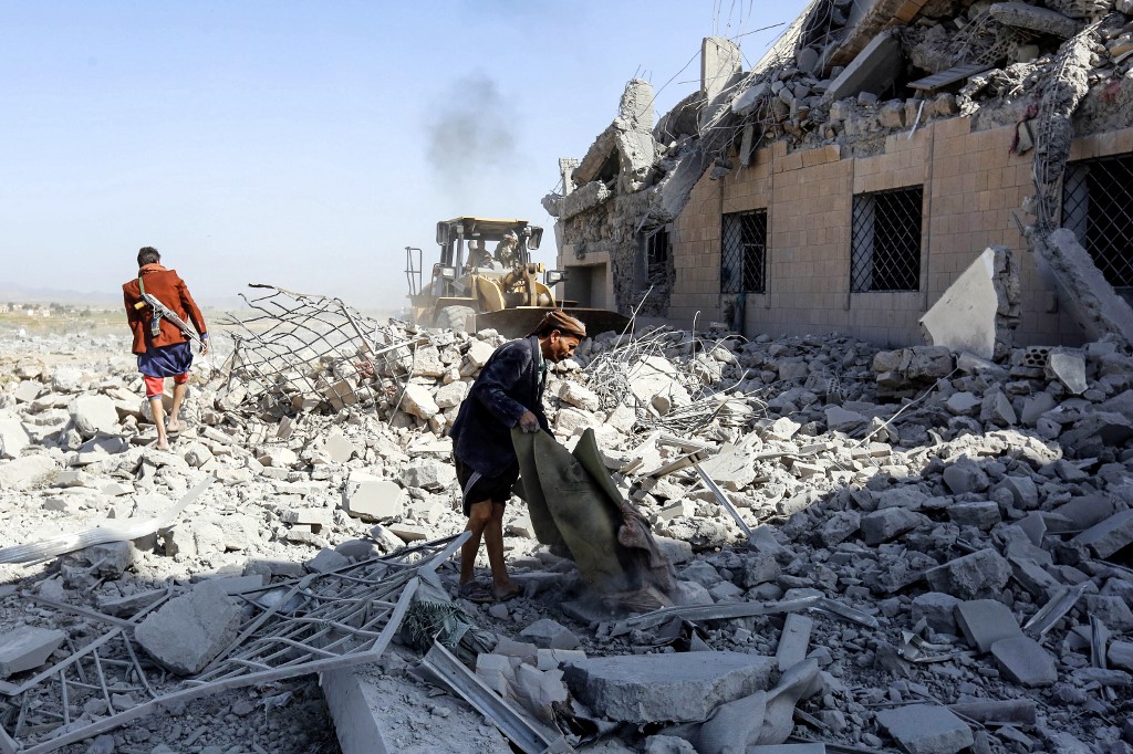 People inspect the rubble of a building hit by an air strike of the Saudi-led coalition south of Sanaa in September 2019 (AFP)