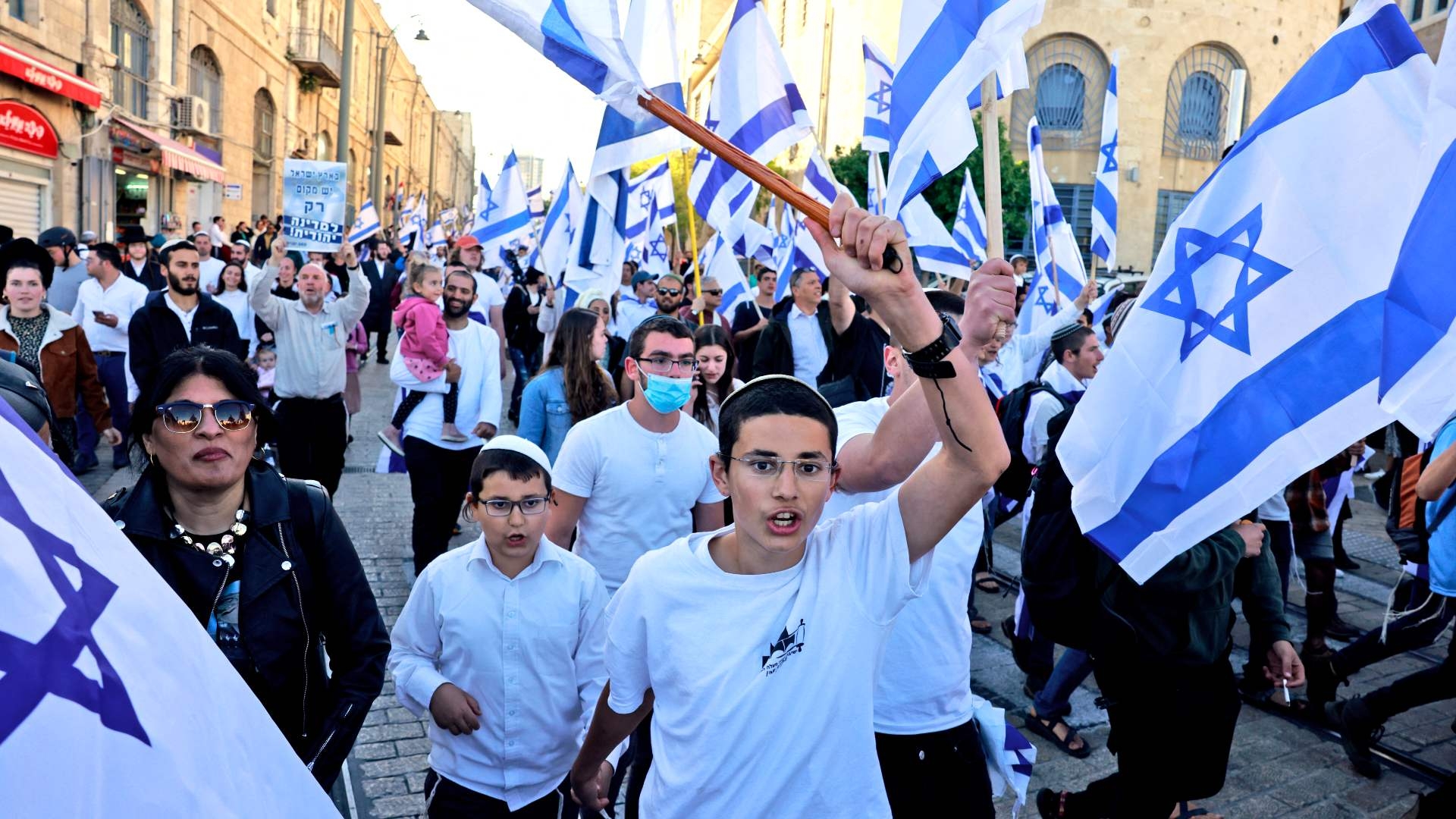 Far-right Israeli protesters wave national flags as they march toward Tzahal Square, on 20 April 2022 (AFP)