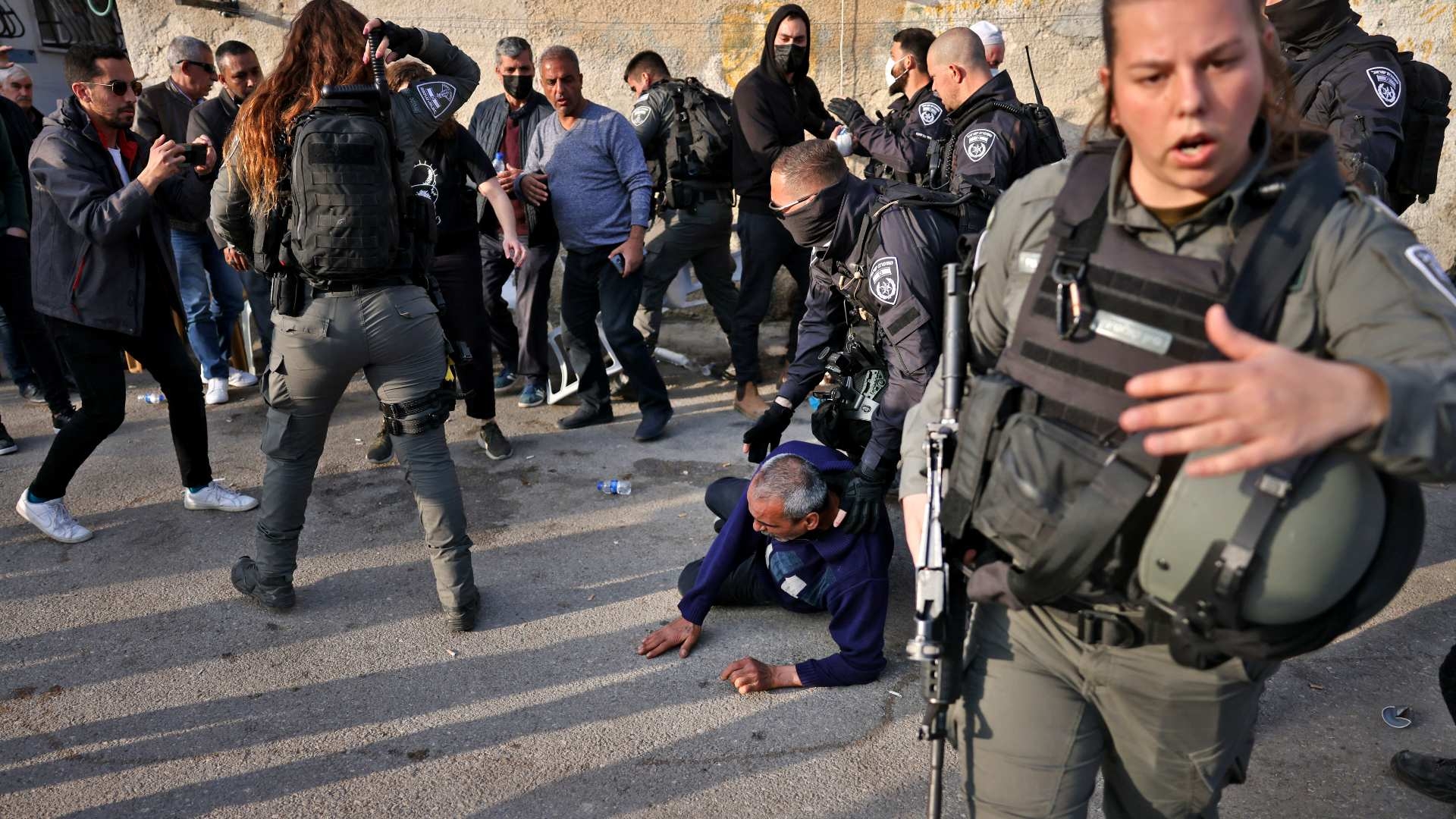 Members of the Israeli border guard stand by as Israeli police detain a man during a protest in the flashpoint East Jerusalem neighbourhood of Sheikh Jarrah on 18 February 2022.