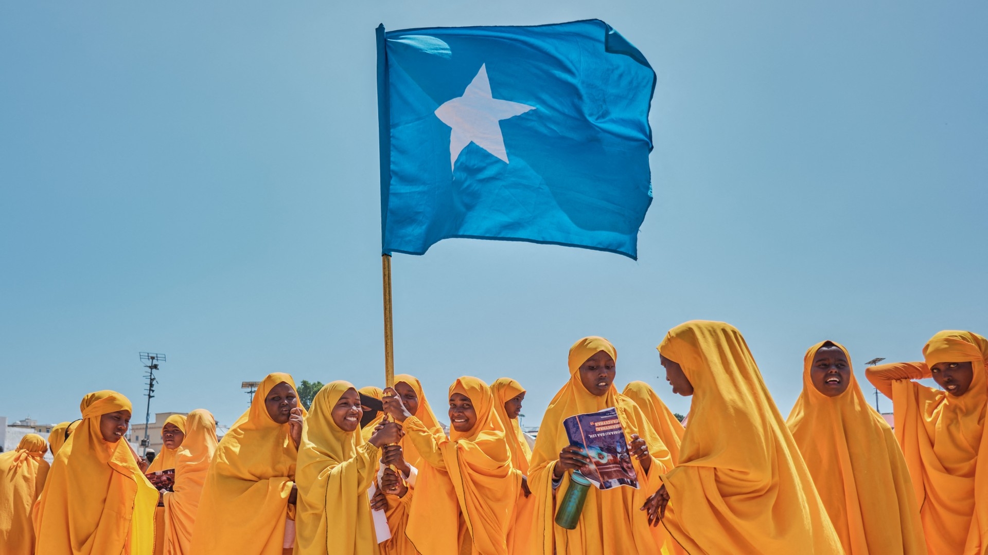 Students wave a Somali flag during a protest following the port deal signed between Ethiopia and Somaliland, in Mogadishu (AFP/Abdishukri Haybe)