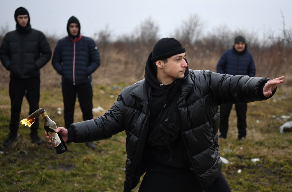 A young man throws a Molotov cocktail during a self-defence course in western Ukraine on 4 March 2022 (AFP)