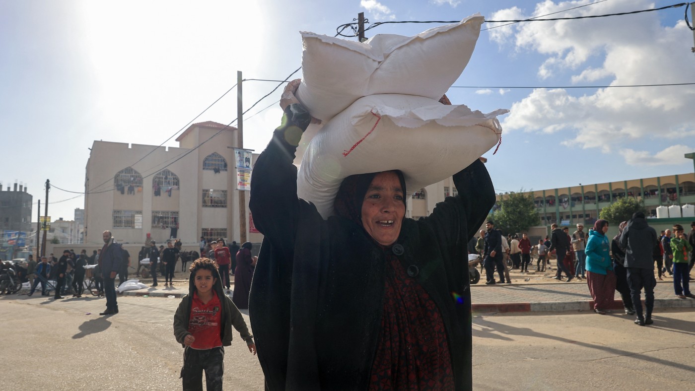 Des Palestiniens reçoivent des sacs de farine de l’UNRWA, en novembre 2023 (AFP)