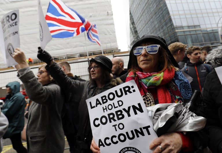 Demonstrators gather outside the head office of the UK Labour Party in London on 8 April 2018 (AFP)