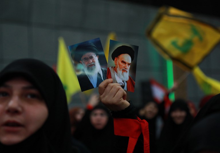 Hezbollah supporters hold images of Ayatollah Ruhollah Khomeini and Ayatollah Ali Khamenei during celebrations marking the 40th anniversary of the Iranian revolution in Beirut on 6 February (AFP)
