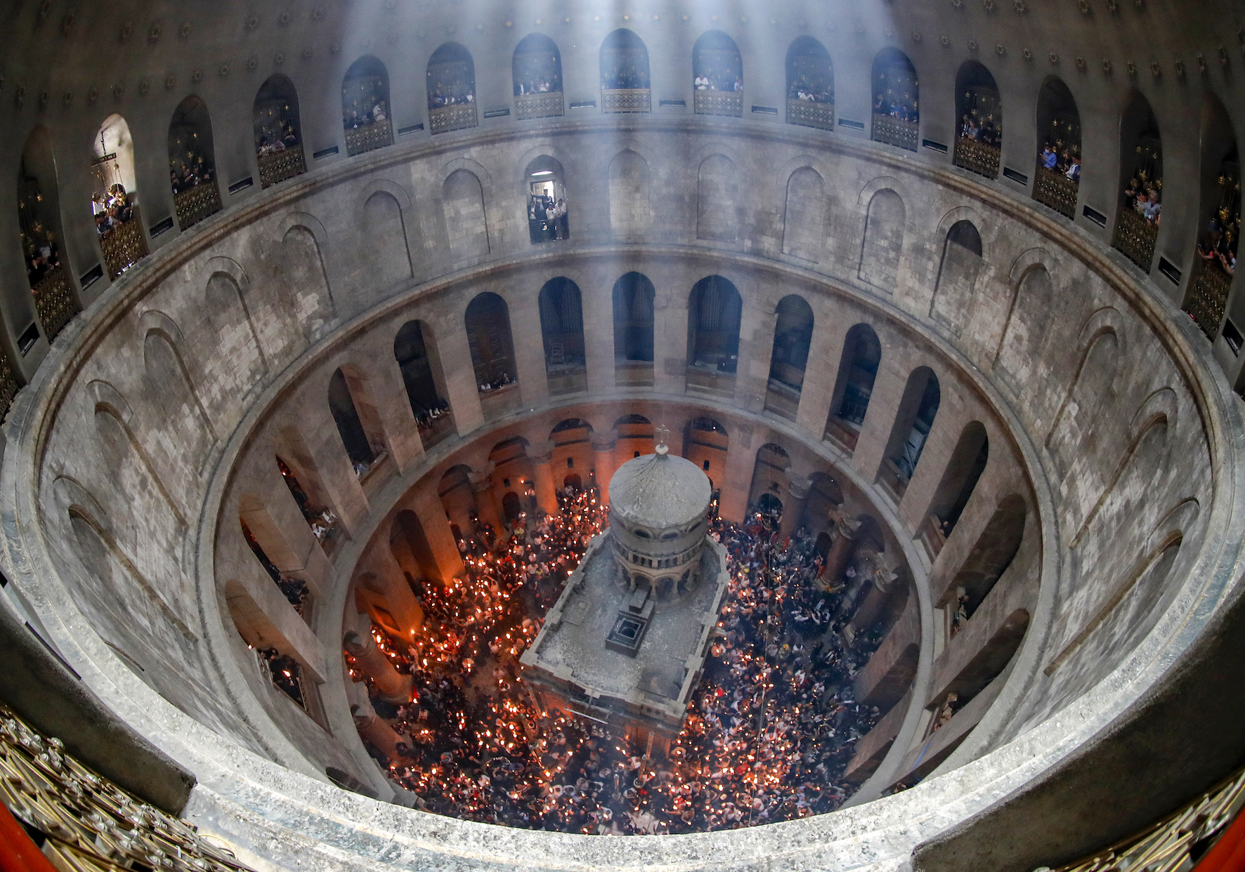 Orthodox Christians gather with lit candles around the Edicule, traditionally believed to be the burial site of Jesus Christ, during the Holy Fire ceremony at Jerusalem's Holy Sepulchre (Ahmed Gharabli/AFP)