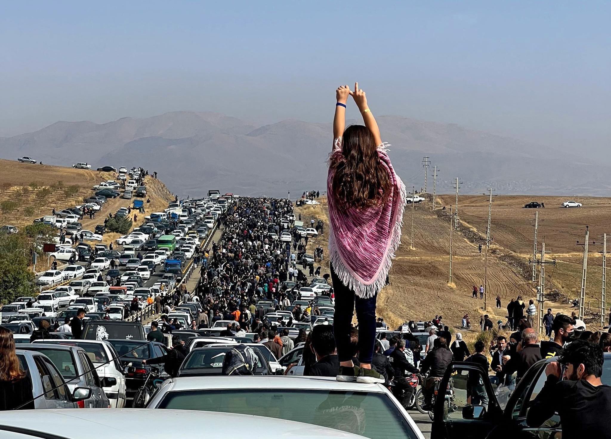 Une image publiée sur Twitter le 26 octobre 2022 montre une femme non voilée sur le toit d’un véhicule alors que des milliers de personnes se dirigent vers le cimetière Aichi de Saghez, ville natale de Mahsa Amini (Reuters)