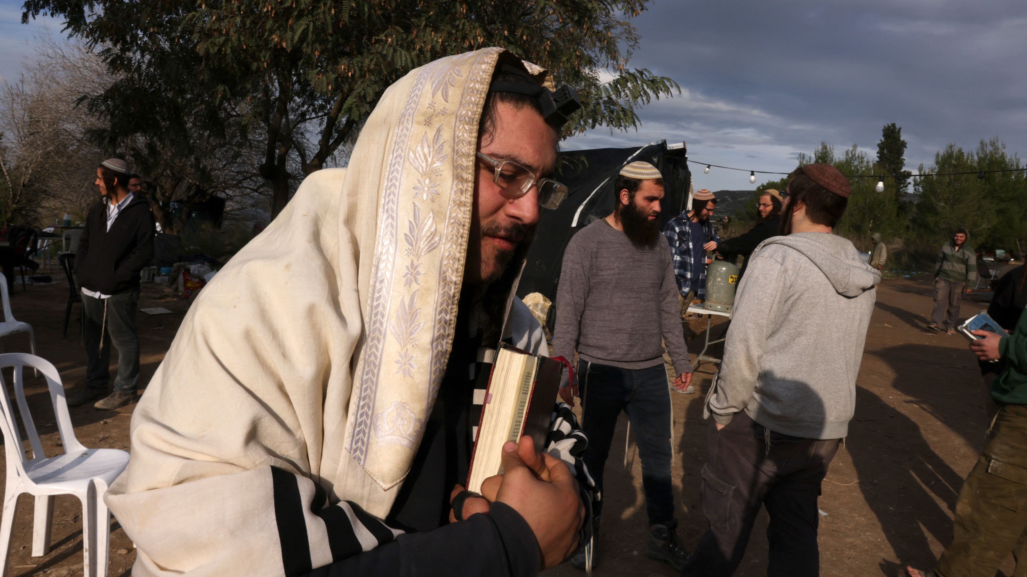 Israeli settlers and students at the Homesh Yeshiva gather at a former settlement near Nablus in the occupied West Bank on 20 December 2021 (Reuters)