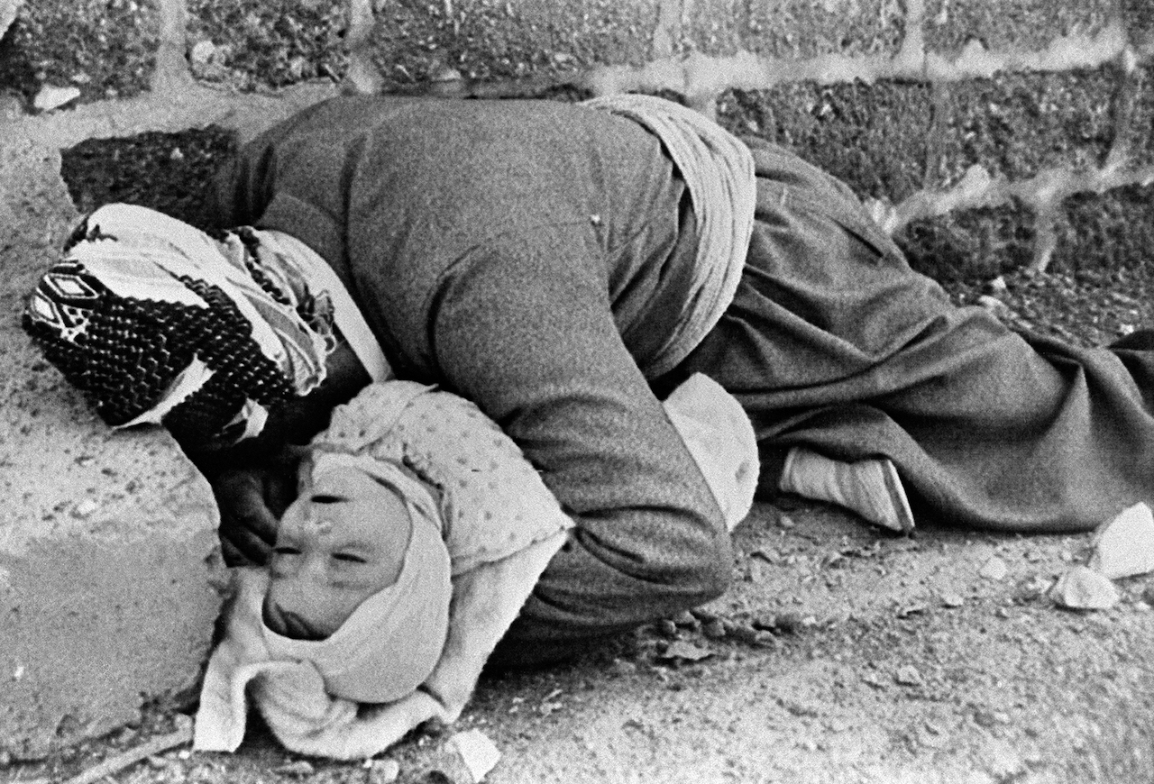 Picture dated March 20, 1988 shows a Kurdish father holding his baby in his arms in Halabja, northeastern Iraq. Both were killed in an Iraqi chemical attack on the city (AFP)