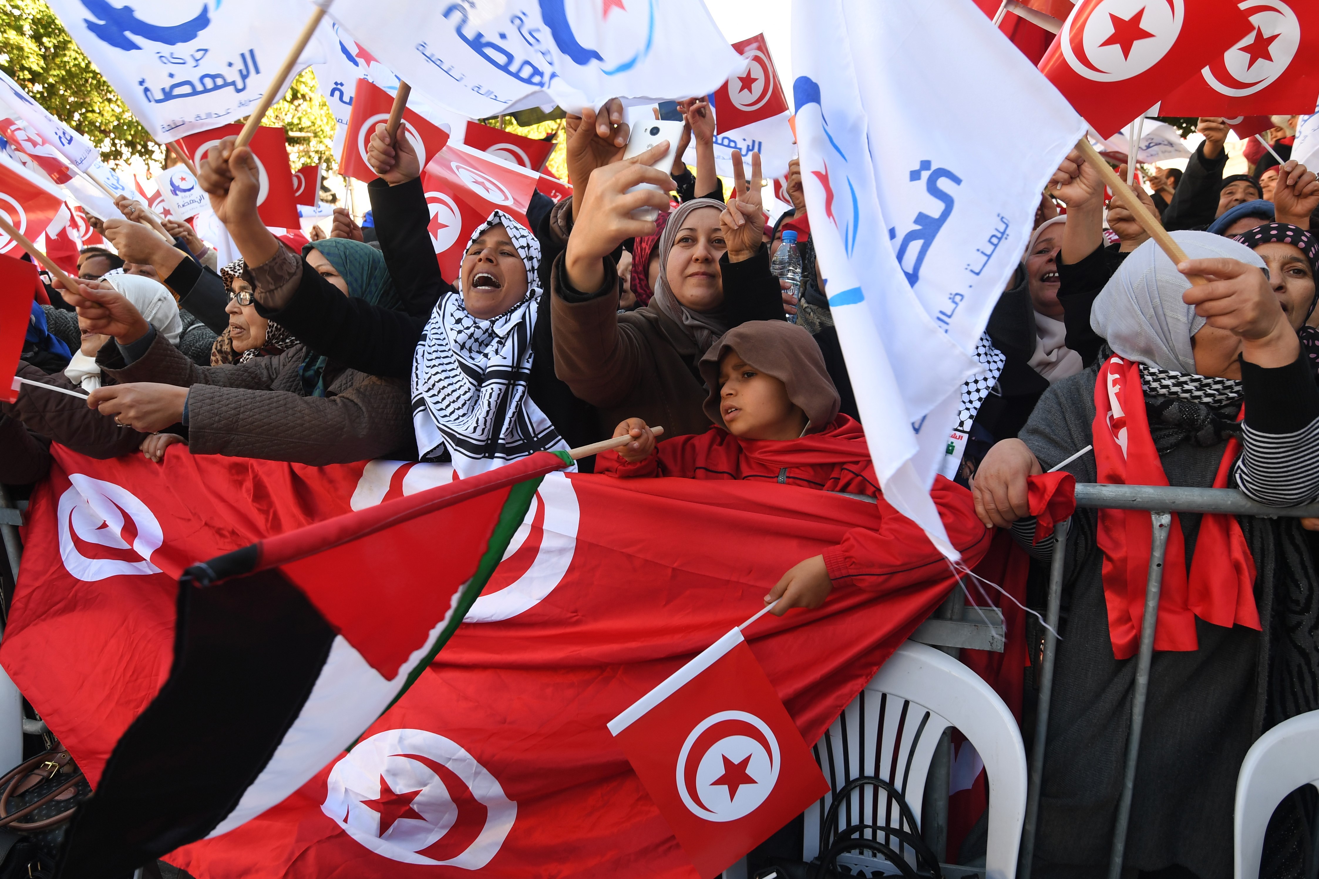 Tunisians wave national flag as they gather on 14 January, 2018 to mark the seven year anniversary since the uprising that launched the Arab Spring (AFP)