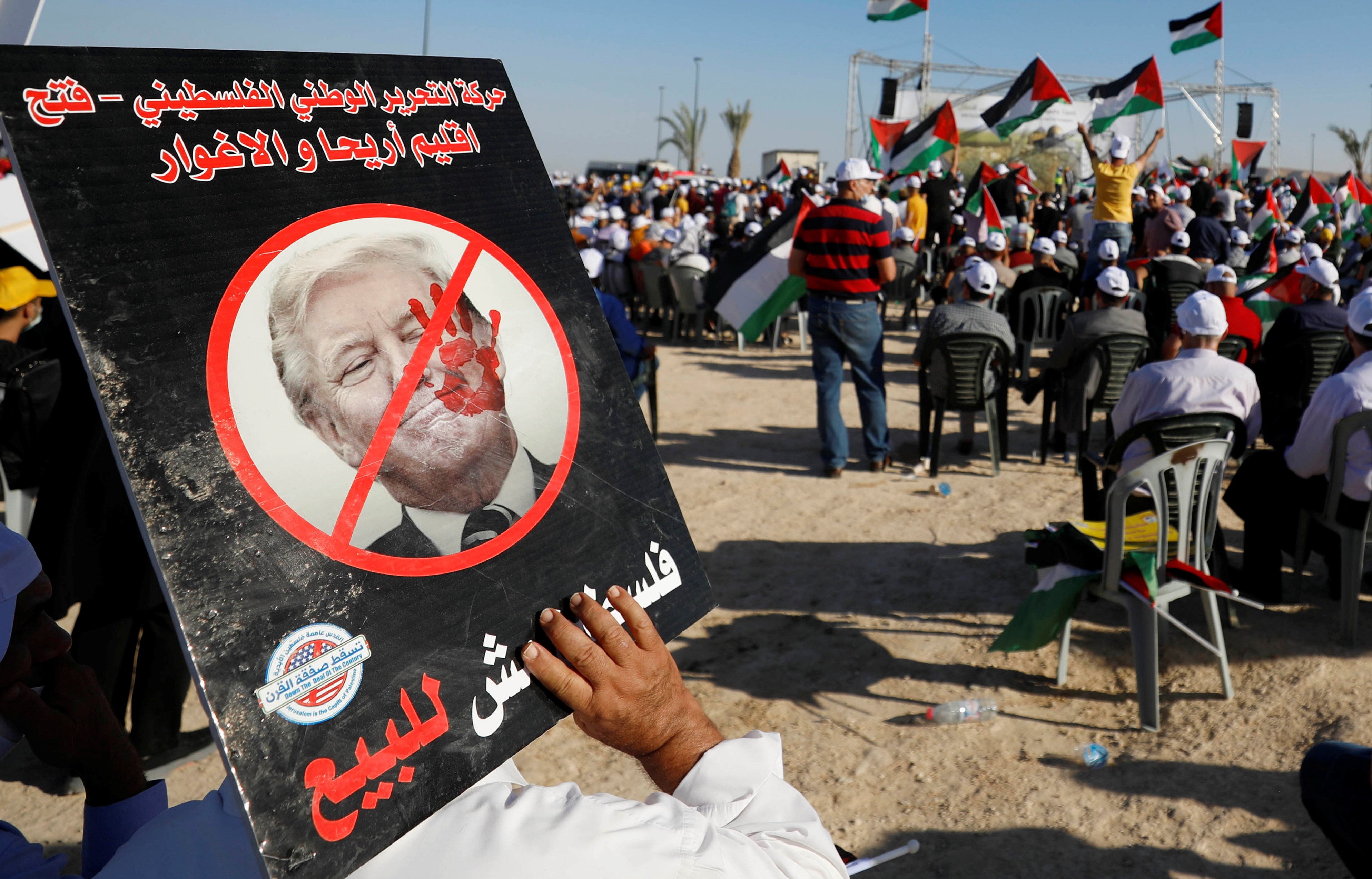  A demonstrator holds an anti-U.S. President Donald Trump placard during a rally, organised by the Palestinian Liberation Organization (PLO), to protest against Israel's plan to annex parts of the occupied West Bank, in Jericho June 22