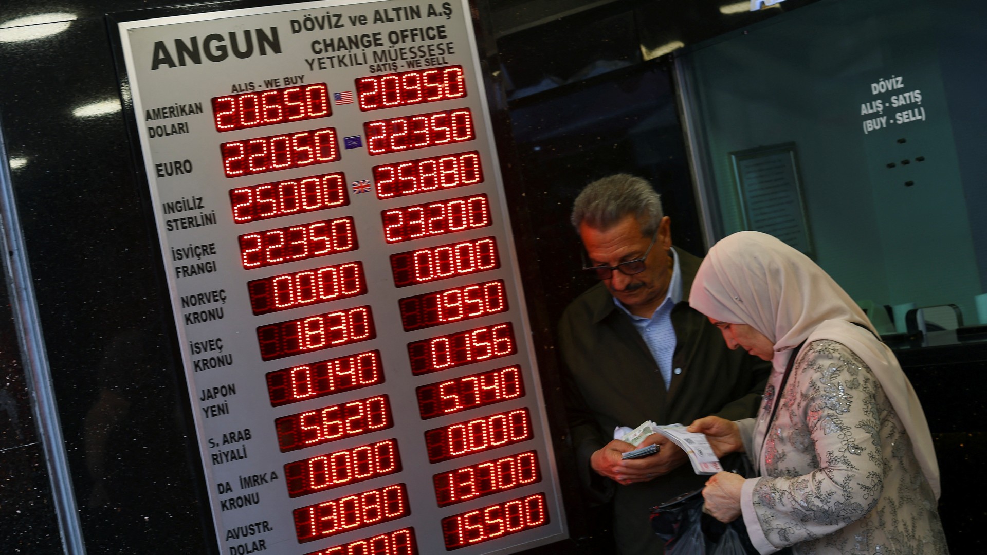 People visit a currency exchange office, after Turkish President Recep Tayyip Erdogan was declared the winner in the second round of the presidential election, in Istanbul, on 29 May (Reuters)