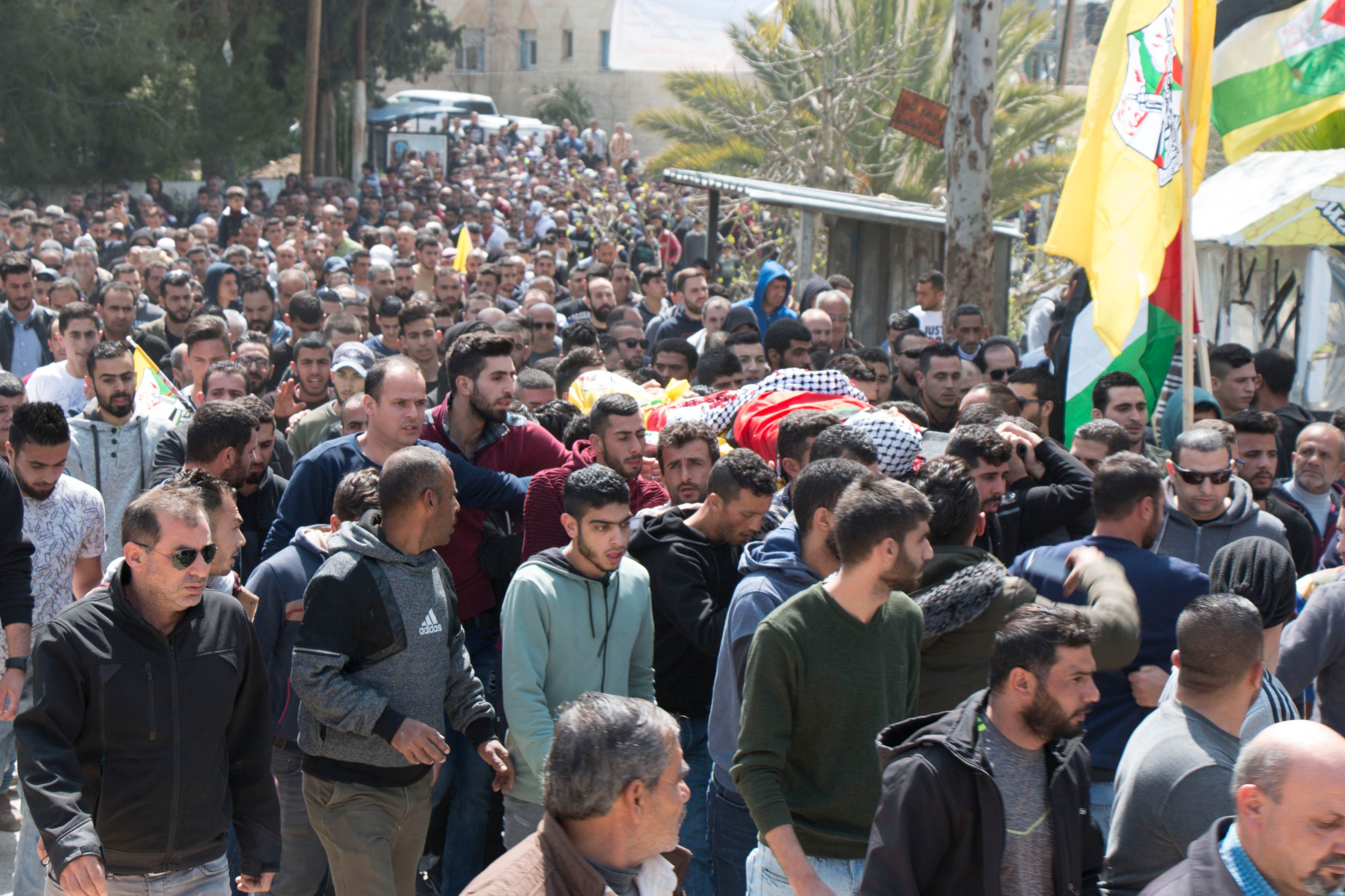Palestinians carry Ahmad Manasrah's body during his funeral procession on Thursday (MEE/Akram al-Waara)