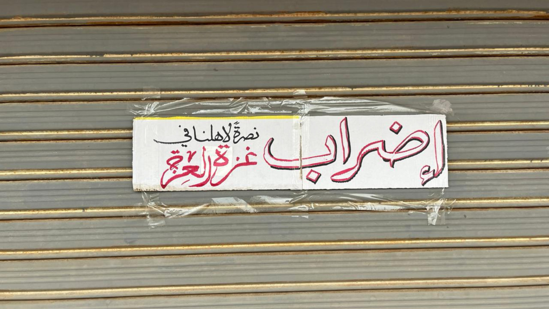 A sign placed on a shuttered shop in the Jordanian capital Amman to announce participation in the global strike for Gaza (MEE/Mohammad Ersan)