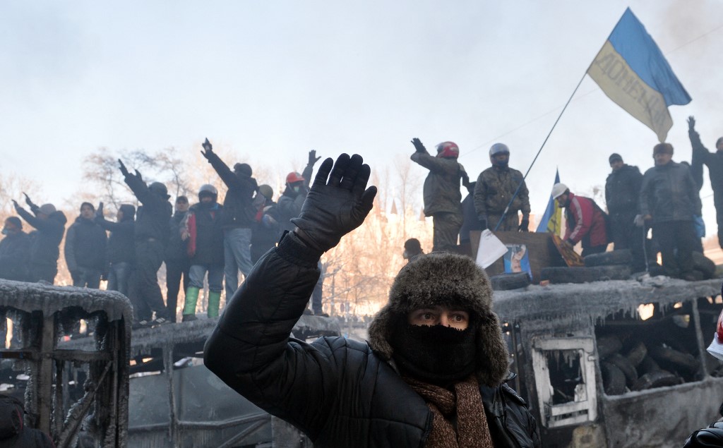 Maidan activists guard a barricade to prevent an attack by the police in the centre of Kyiv on 24 January 2014 (Sergei Supinsky/AFP)