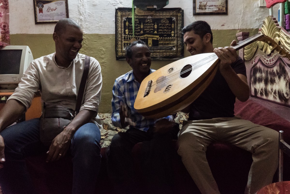 Vik Sohonie (R), founder of Ostinato Records, and project coordinator Ahmed Asyouti (L) during a meeting with singer Emad Youssef at his home in Khartoum in 2017 (Janto Djassi)
