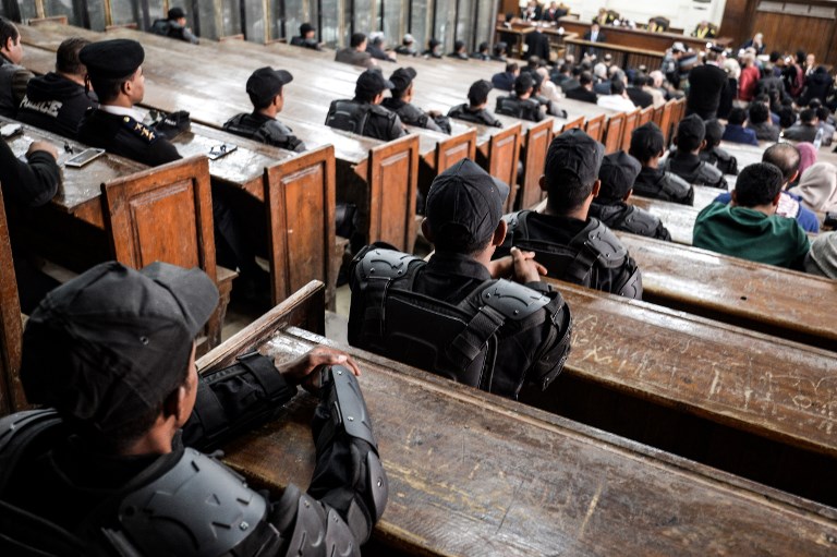 Members of the Egyptian security forces                    sit in a Cairo courthouse on 2 December (AFP)