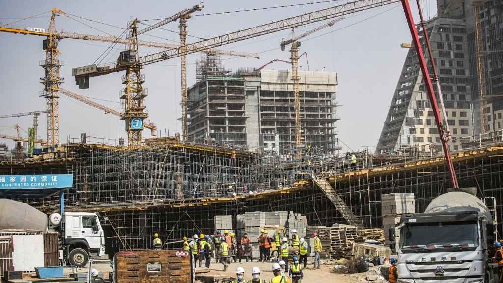 Construction workers build Egypt’s ‘new administrative capital’ mega-project east of Cairo on 3 August 2021 (AFP)