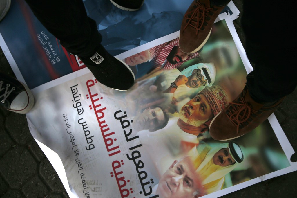 Palestinians step on a placard displaying pictures of Gulf, Israeli and US leaders during a protest in Gaza City in June 2019 (AFP)
