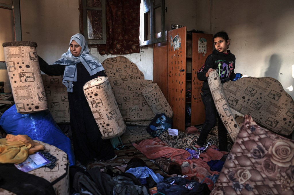 Palestinians inspect the damage at home following Israeli bombardment in Rafah in the southern Gaza Strip on December 26, 2023,