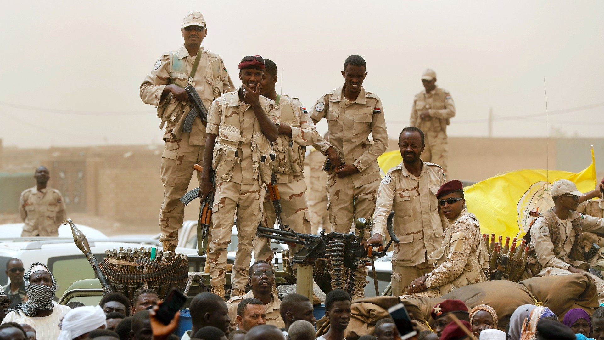 Sudanese soldiers from the Rapid Support Forces unit stand on their vehicle during a military-backed rally, in Mayo district, south of Khartoum on 29 June (AP)
