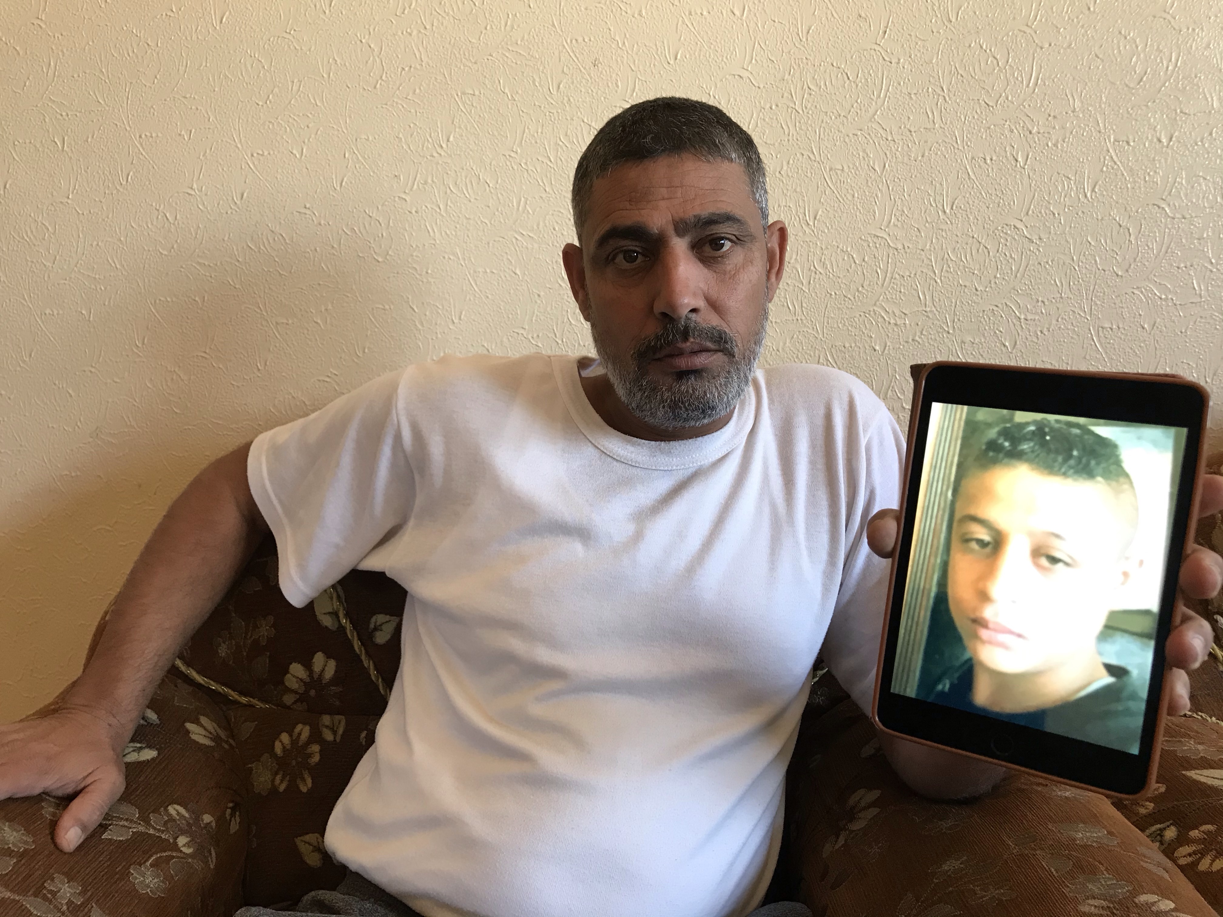 Othman Hilles' father Rami holds a picture of his dead son (MEE/Moatasim Dalloul)