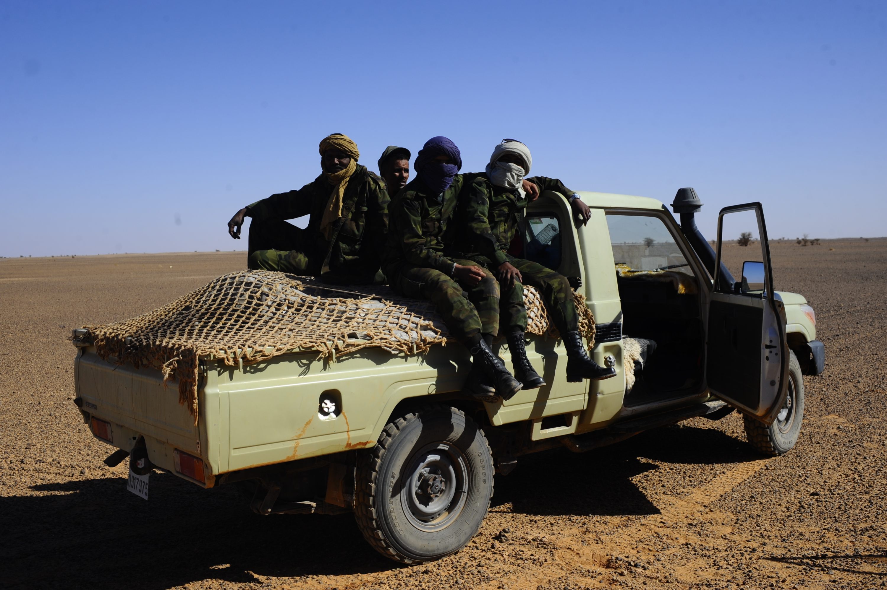 Members of the Polisario sit on a pick-up truck in the Western Sahara in 2014 (MEE/Oscar Rickett)