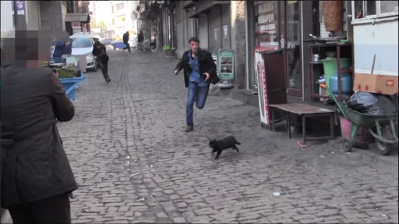 A still shows a suspected PKK militant running down a street being targeted by police (screenshot)
