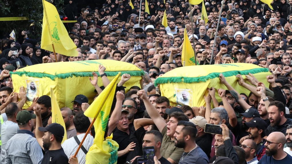 Des personnes assistent aux funérailles de deux membres du Hezbollah dans le village de Khirbet Selm, dans le sud du Liban, le 10 octobre 2023 (AFP)