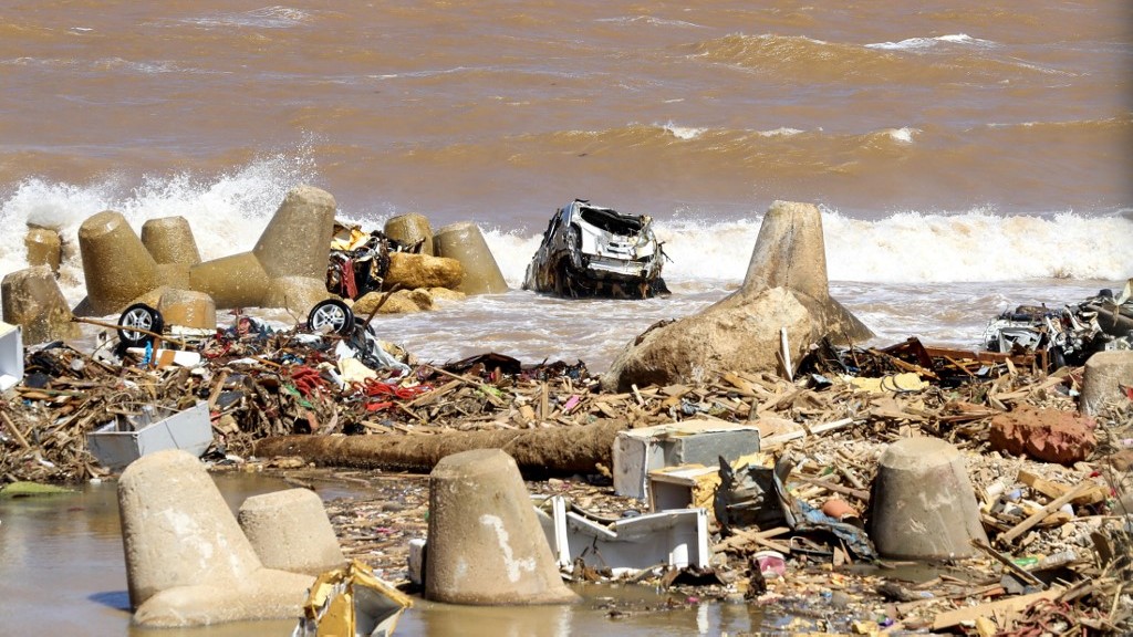 Une carcasse de voiture au bord de la mer à Derna après les inondations, le 19 septembre 2023 (AFP)