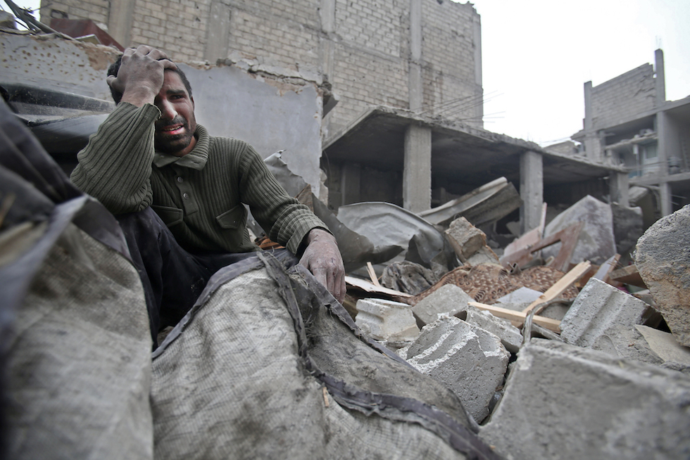 A Syrian man mourns over his destroyed home in the rebel-held besieged town of Arbin, in the Eastern Ghouta region on the outskirts of the capital Damascus (AFP)