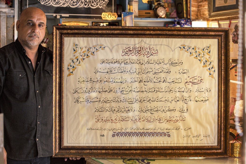 Le calligraphe irakien Wael al-Ramadan pose pour une photo avec sa calligraphie arabe (AFP)
